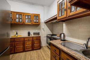 a large kitchen with wooden cabinets and a sink at Apartamento Típico - Vila Mafra in Nazaré +20 photos