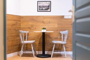 une table et deux tabourets devant un mur en bois dans l'établissement Appartement cosy proche de la citadelle, à Bastia