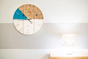 a clock hanging on a wall in a living room at Travel Station Apartment by Pleiades Home in Livorno