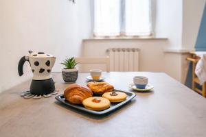 a table with a plate of pastries and cups of coffee at Travel & Station Apartament in Livorno