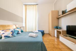 a bedroom with a bed and a flat screen tv at Travel Station Apartment by Pleiades Home in Livorno