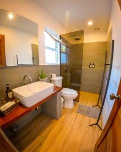 a bathroom with a tub and a sink and a toilet at Yellow Mango Resort Bohol in Panglao Island