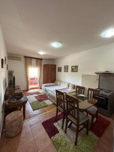 een woonkamer met een tafel en een bank bij Bella Apartman in Podgorica