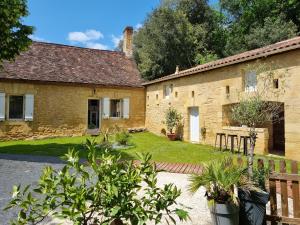 an old stone house with a garden in front of it at Le Clos de la Canéda in Sarlat-la-Canéda