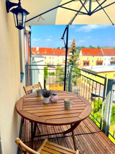 uma mesa de madeira numa varanda com um guarda-chuva em Elbling Apartment mit Terrasse - Netflix - Parkplatz - Weinbergblick em Meißen