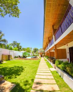 a walkway next to a building with a grass yard at Yellow Mango Resort Bohol in Panglao Island