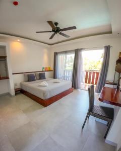 Schlafzimmer mit einem Bett und einem Deckenventilator in der Unterkunft Yellow Mango Resort Bohol in Panglao