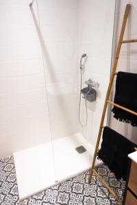 een douche in een witte badkamer met een douche bij Appartement cosy proche de la citadelle in Bastia