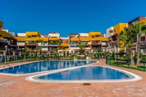 an empty swimming pool in front of a building at Casa El Bosque, Playa Flamenca, Orihuela Costa in Playa Flamenca