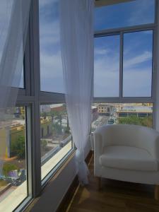 a living room with a white chair and a large window at Sky Puerto in Puerto del Rosario