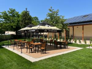 un patio al aire libre con mesas, sillas y sombrillas en Inter Hotel, en Debrecen