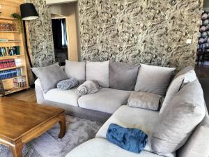 sala de estar con sofá blanco y mesa en Le Gîte des Trois Seigneurs, en Rabat-les-Trois-Seigneurs