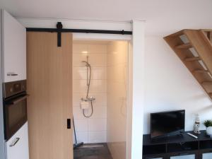 een badkamer met een douche en een televisie in een kamer bij Appartement ,Vakantiewoning, Koddelaan 29 in Zoutelande