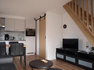 een keuken en een woonkamer met een tafel en een keuken bij Appartement ,Vakantiewoning, Koddelaan 29 in Zoutelande