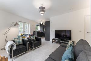 uma sala de estar com um sofá e uma televisão em Mhuilinn Apartment em Stirling
