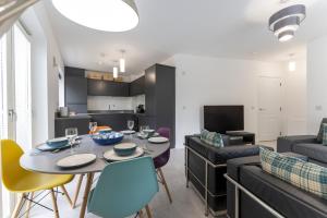 a dining room and living room with a table and chairs at Mhuilinn Apartment in Stirling