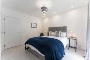 a bedroom with a bed with a blue blanket on it at Mhuilinn Apartment in Stirling