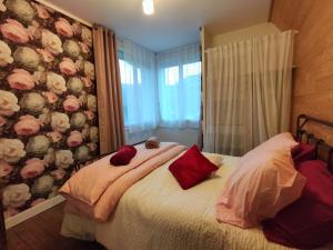 Un dormitorio con una cama con almohadas rojas. en Le Gîte des Trois Seigneurs, en Rabat-les-Trois-Seigneurs