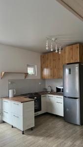 a kitchen with a stainless steel refrigerator and wooden cabinets at Malina guest house in Bosteri