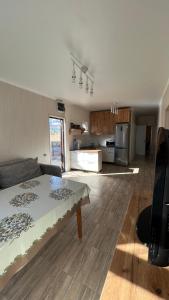 a living room with a bed and a kitchen at Malina guest house in Bosteri