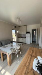 a living room with a table and a kitchen at Malina guest house in Bosteri