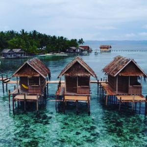a group of huts in the water on a beach at Kayafyof Homestay in Besir