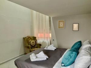 una camera da letto con un letto con cuscini blu e una sedia di Casa Scugnizzella a Napoli
