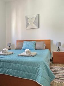 a bedroom with a blue bed with towels on it at Serra Mar in Cruz de João Mendes