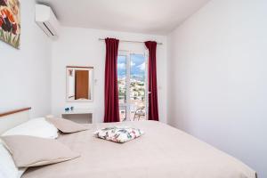 Cama con almohada en una habitación con ventana en Apartment Marieta, en Dubrovnik