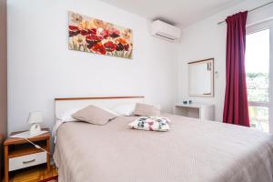 1 dormitorio con 1 cama blanca grande y ventana en Apartment Marieta, en Dubrovnik