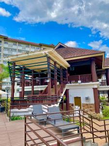 a building with a deck with benches and an umbrella at MQ Staycation at One Oasis in Cagayan de Oro