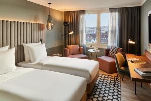 a hotel room with a bed and a desk at Pullman Stuttgart Fontana in Stuttgart