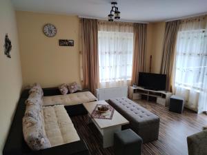 a living room with a couch and a tv at Апартамент за гости „Виктория“ in Chepelare