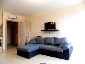 un salon avec un canapé et une télévision à écran plat dans l'établissement 58 - Hullám Üdülőparkban vízközeli modern stúdió apartman, à Balatonőszöd 1 autre photo