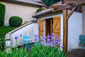 Monestier-de-Clermont的住宿－guesthome la petite salette，一座花园,在房子前面种有紫色的花朵