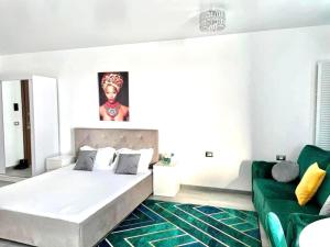 a bedroom with a bed and a green couch at Studio Philip by Alezzii Nord 10 in Năvodari +26 photos