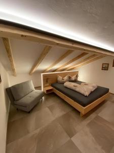 a bed and a chair in a room at apart lobenwein in Pfunds