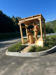 una estatua de dos personas bajo una estructura de madera en Alloggio Silvia en Lisio