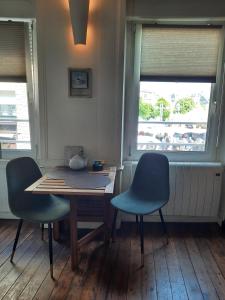 - une table et des chaises dans une chambre avec fenêtre dans l'établissement Studio Le Ras d'Eau à Granville, à Granville