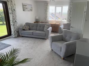 a living room with couches and chairs and a window at Idyllic holiday near Abersoch in Mynytho