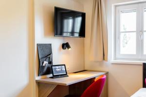 a room with a desk with a laptop and a window at Hotel Rosenvilla in Salzburg