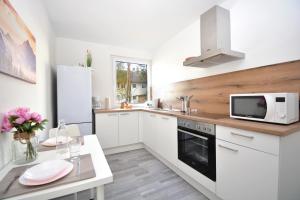 cocina con armarios blancos, fregadero y microondas en CO05-HI Apartment in Coburg, en Coburg