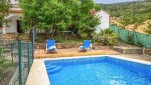 - deux chaises bleues installées à côté de la piscine dans l'établissement Los Lirios Jimera de Libar by Ruralidays, à Jimera de Líbar