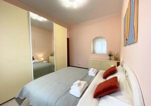 een slaapkamer met een bed met rode kussens en een spiegel bij Appartamento 2, Villa Magnolia, 64mq, Lago di Garda in Peschiera del Garda