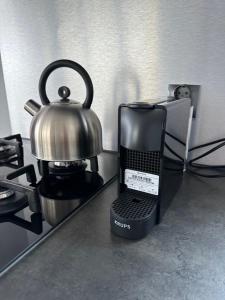a tea kettle is sitting on top of a stove at Stoere HOUSEBOAT op toplocatie! in Belt-Schutsloot