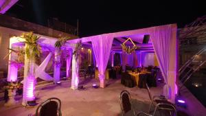 Ratna Hotel & Banquet في مظفربور: مكان زواج مع اضاءة ارجوانية وطاولة