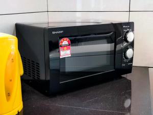 a black toaster oven with a sticker on it at AVENUE HOMESTAY 5 Room 4 Toilet 4 MINUTES TO TOWER in Teluk Intan