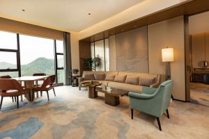 a living room with a couch and a table and chairs at Wyndham Garden Gaozhou in Gaozhou