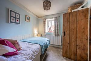 a bedroom with a bed and a large wooden door at Yew Tree Cottage in Blakeney