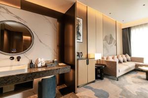 Cette chambre d'hôtel dispose d'un lavabo et d'un canapé. dans l'établissement Wyndham Garden Gaozhou, à Gaozhou